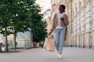 Happy shopper walking down the street using smartphone © Zamrznuti tonovi