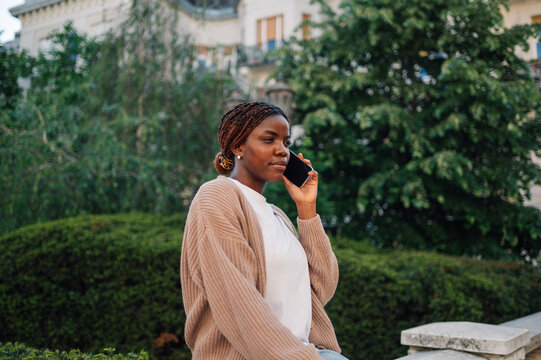 Young woman making a phone call outdoors in a park