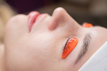 Caucasian woman undergoing eyelash lamination procedure. 
