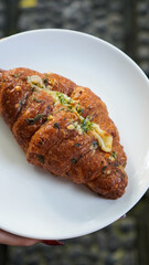 Savory Garlic Cheese Croissant on White Plate – Close-Up of Flaky Baked Pastry