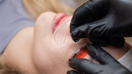 Caucasian woman undergoing eyelash lamination procedure. 