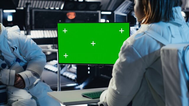 Team of cosmonauts calibrating starship sensors using isolated screen monitor, preparing for mission. Astronauts using chroma key display, beginning landing procedures on solar system planet
