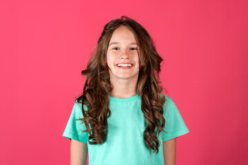 Fototapeta na wymiar Happy smiling european young cheerful 11-year girl portrait on pink background