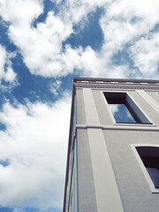 Close-up of a building's upper corner showcasing architectural details against a clear blue sky....