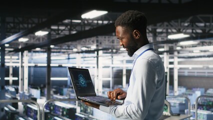 Programmer and colleague in data center reviewing AI LLM visualizations on laptop. IT teamworking...
