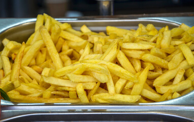 Crispy golden French fries arranged in a metallic tray, perfect for a quick snack. A delicious...