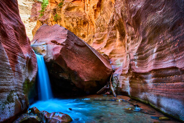 Waterfall Motion Over Angular Boulder in Striated Sandstone Canyon Eye Level View