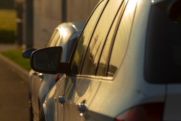 There are two cars parked side by side next to each other on the side of the road, creating a scene...