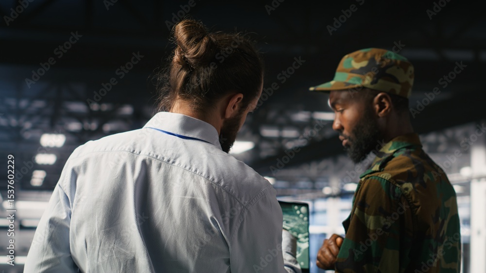 Poster military technician reviewing tactical dashboard on laptop screen inside secure server hub. army exp