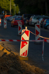 A prominently displayed row of red and white construction signs placed strategically along the side...