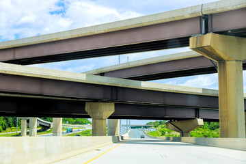 Fototapeta premium Multiple highway overpasses create unique architectural view under with vehicles traveling below.