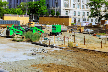Heavy machinery works on construction site while various materials are organized for building...