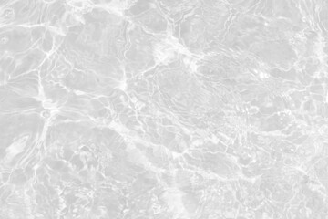 White water with ripples on the surface. Defocus blurred transparent white colored clear calm water surface texture with splashes and bubbles. Water waves with shining pattern texture background.