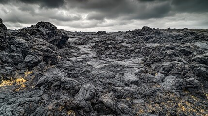 Obraz premium Dark Lavascape Under Overcast Sky in Volcanic Landscape Exploration