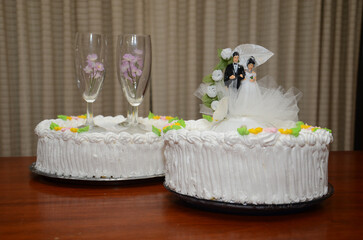 Elegant wedding cakes with frosting and bride and groom figurine for celebration