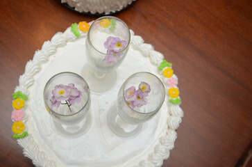 Elegant floral cake decoration with champagne glasses on a wooden table