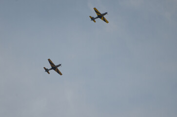 Vintage planes in synchronized aerial display against a clear sky