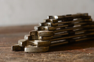Stacked metal wrenches in stair formation on rustic wooden surface