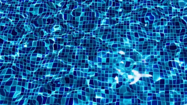 Deep blue swimming pool water surface with sun reflections