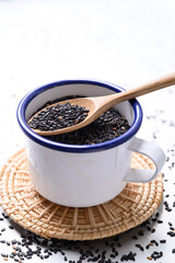 Black sesame seed in wooden spoon and bowl, Food ingredient