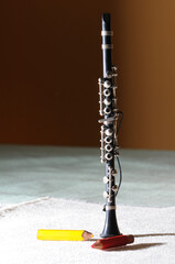 Black clarinet on light carpet with red sharpener and yellow pencil
