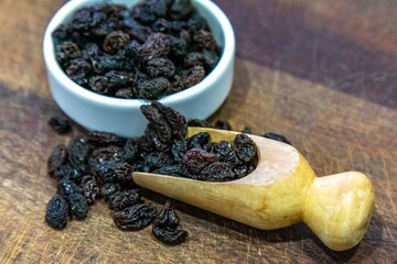 Black seedless raisins in rustic setting and selective focus