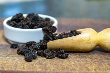 Black seedless raisins in rustic setting and selective focus