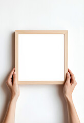 Close-up of woman's hands holding a wooden mock-up poster frame