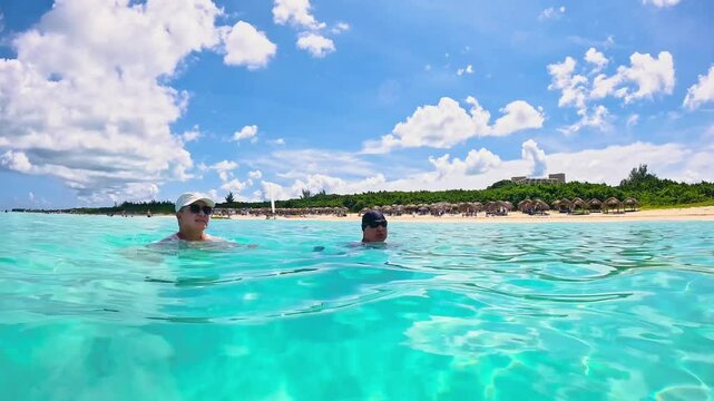 Senior couple swimming in crystal-clear Caribbean waters, Varadero Beach, Cuba