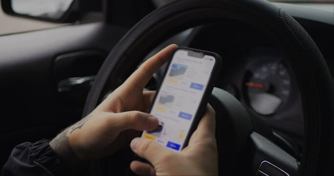 Man chooses to buy car on site. Looking at used vehicle to buy on smartphone app.  Screen is blurred. Close Up. 4K UHD. 