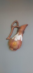 Vintage Decorative Pitcher: A vintage pitcher ornament in hues of brown and cream, delicately...