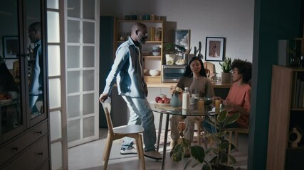 Full shot of cheerful young polyethnic female army soldier in military t-shirt, African American husband and biracial son preparing to have breakfast together in morning, before leaving for service