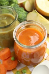 Baby food. Tasty puree in glass jars and ingredients on table, closeup