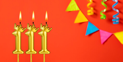 Number 111 candle - Birthday celebration on an orange background with pennants