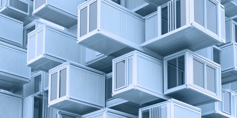 Obraz premium Stacked blue containers with windows form a modern architectural pattern. Modular housing, urban design, innovation