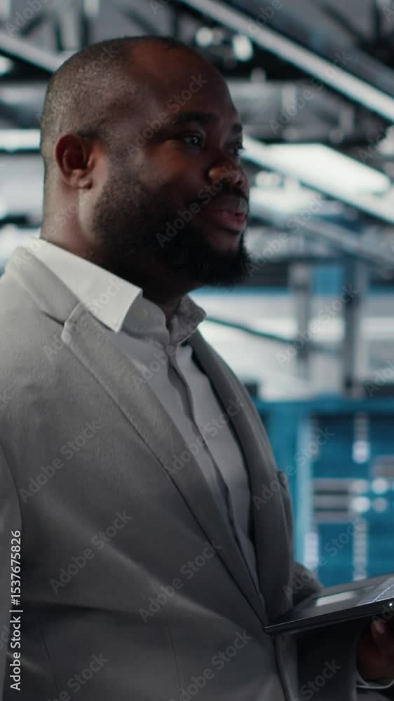 Poster vertical video smiling data center programmer using laptop to upgrade system stability. jolly africa