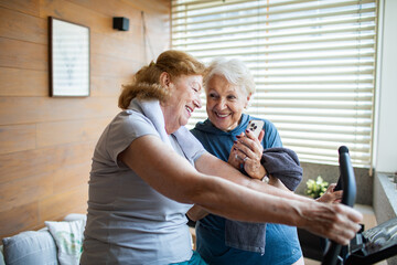 Senior lesbian couple exercising together at home and cheering each other on