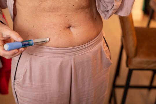 Woman Using Semaglutide Injection Pen for aesthetic purposes