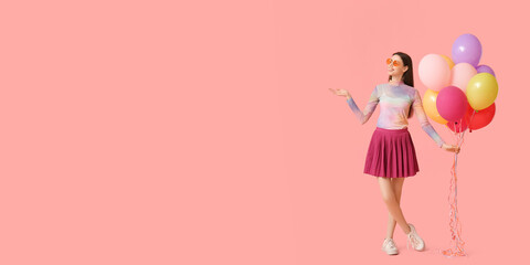 Beautiful young woman with colorful balloons on pink background with space for text