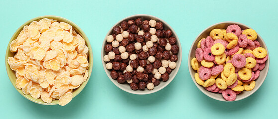 Bowls of different tasty breakfast cereals on turquoise background, top view