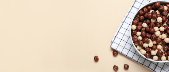 Bowl with chocolate corn balls on beige background with space for text