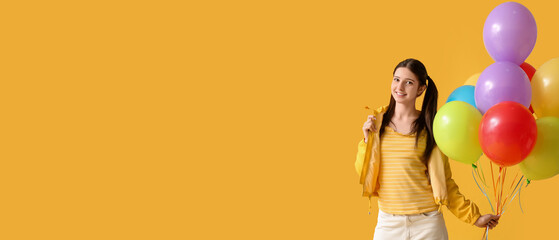 Fototapeta premium Teenage girl with colorful balloons on yellow background with space for text
