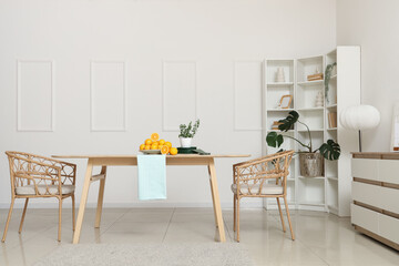 Interior of light room with shelf unit and oranges on dining table