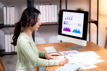 Young asian businesswoman planning and strategy about finance looking graph and chart of report marketing in home office, business woman analyzing financial and revenue for success, business concept.