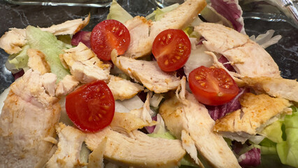 Close-up of a healthy chicken salad with fresh lettuce and cherry tomatoes
