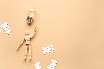 Wooden mannequin with light bulb and puzzle pieces on beige background. Logic concept