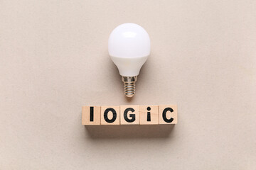 Wooden cubes with word LOGIC and light bulb on grey background. Logic concept