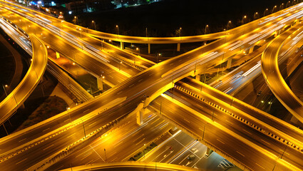 Elevated highway interchange at night with light trails