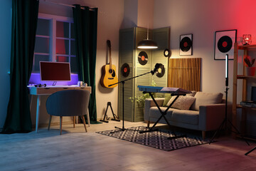 Interior of dark recording studio with workplace, sofa and musical instruments