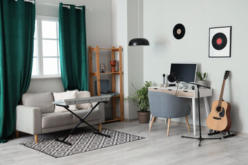 Interior of recording studio with workplace, sofa and musical instruments